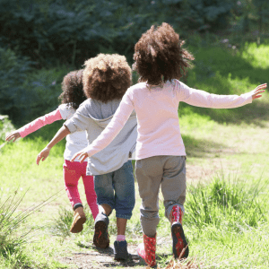 Three young children walking on a nature path