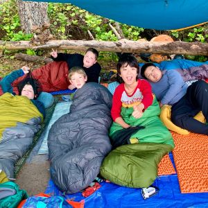 A group of young men wake up in their sleeping bags on the coast of the Olympic Peninsula