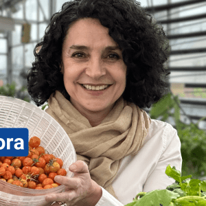Photo of a smiling woman holding a bowl of tomatoes with text on the left that reads, "Environmental Education. Manuela Zamora. New York Sun Works"