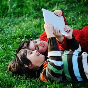 Two young children laying in the grass looking up