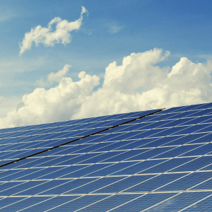 Solar panels with a cloudy blue sky behind them
