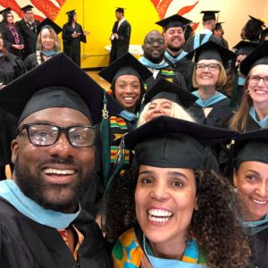 Photo of a group of smiling people wearing caps and gowns
