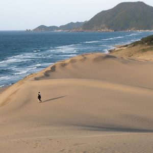 sand dunes near water and a hill