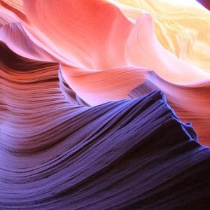 Colorful, wavy sedimentary rock awash in hues of purple, red, and yellow.