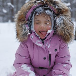 child in snow with tongue sticking out