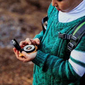 Child holding compass in the woods