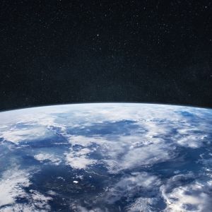 Amazing blue planet earth with ocean, clouds and continents in open space on the starry sky.