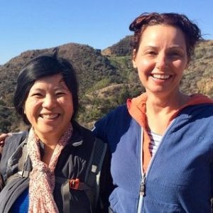 Two people smiling toward the viewer with a California landscape in the background