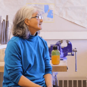 Bessie Sinnok and Isau Sinnok, Shishmaref, Alaska face one another in a classroom