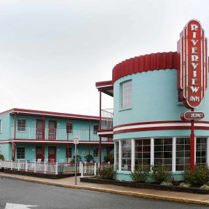 Photo of a blue inn with a retro facade on the corner of a street