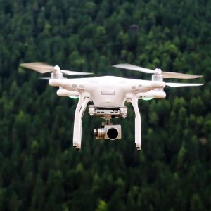 Photo of a drone flying above a forest