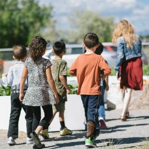 group of students following their teacher outside towards a school garden