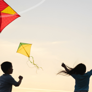 Silhouette of kids playing with kites