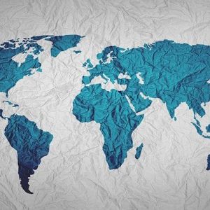 A world map with landforms in blue on wrinkled fabric