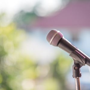 Microphone in a stand over a blurred background of green trees