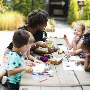 educator with young children outside working on nature art