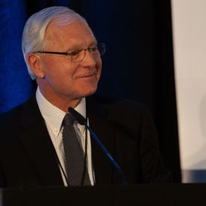 John Flciker smiling at a podium