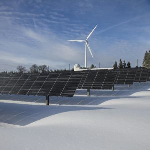 Solar Panels on Snow With Windmill Under Clear Day Sky
