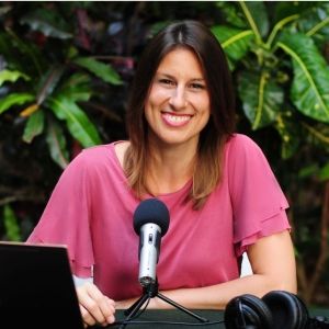 Crystal DiMiceli in front of a mic and computer while outside.