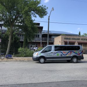 Photo of a gray van parked next to a brown building