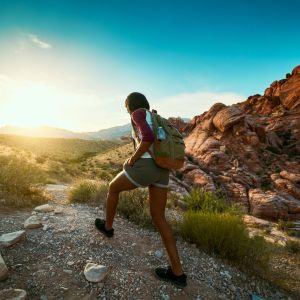 Dramatic shot of person with backpack walking through canyon.