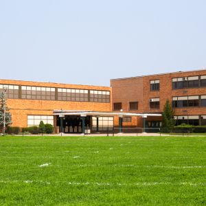 School sitting behind a field of bright, green grass.