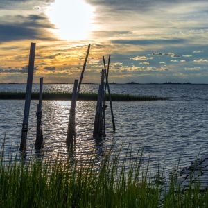 sun peaking through clouds over chesapeake bay