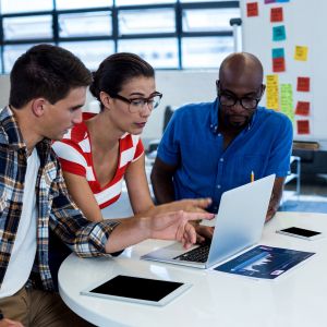 three people looking at computer in office