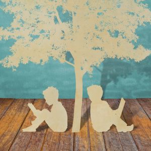 paper cutouts of two students reading under tree, sitting on brown wood floor in front of suggested painted blue bricks