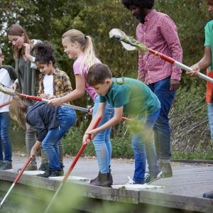 Students and teachers on a dock near a river