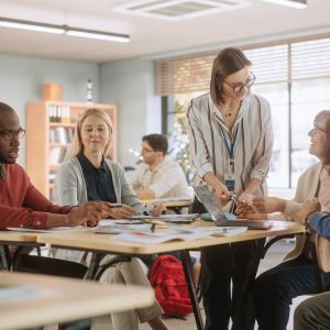 Teachers gather around a table reviewing and interacting with educational materials