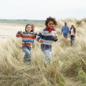 young kids with adults running through grass