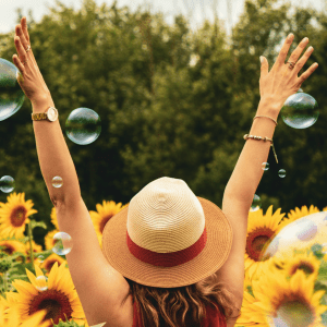 A woman with arms outstretched in a field of sunflowers