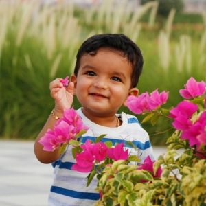 young child playing with pink flowers