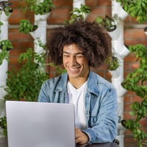 Young man smiling at his laptop