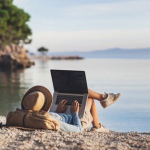 Woman on beach with laptop