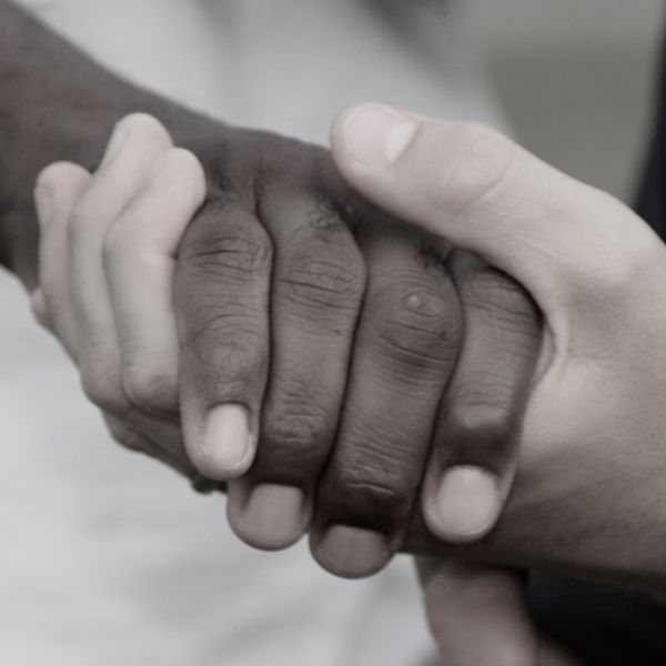 two hands of different skin tones clasping