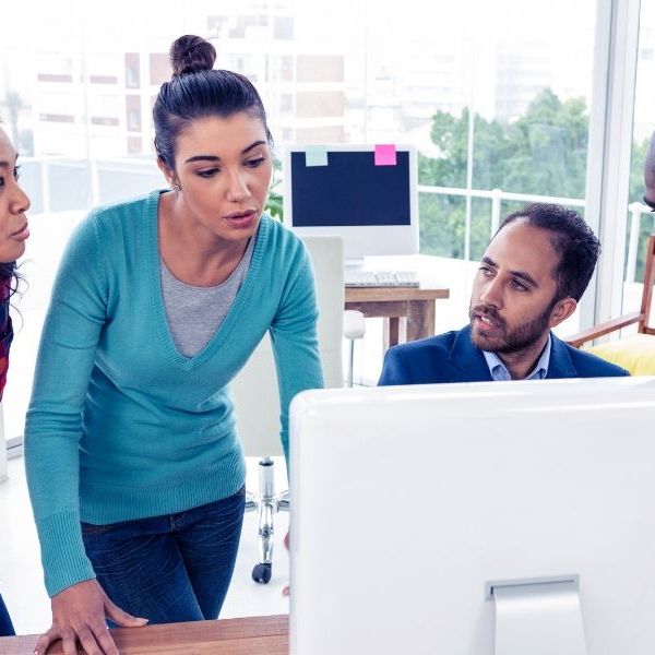 Four people in front of a computer deliberating