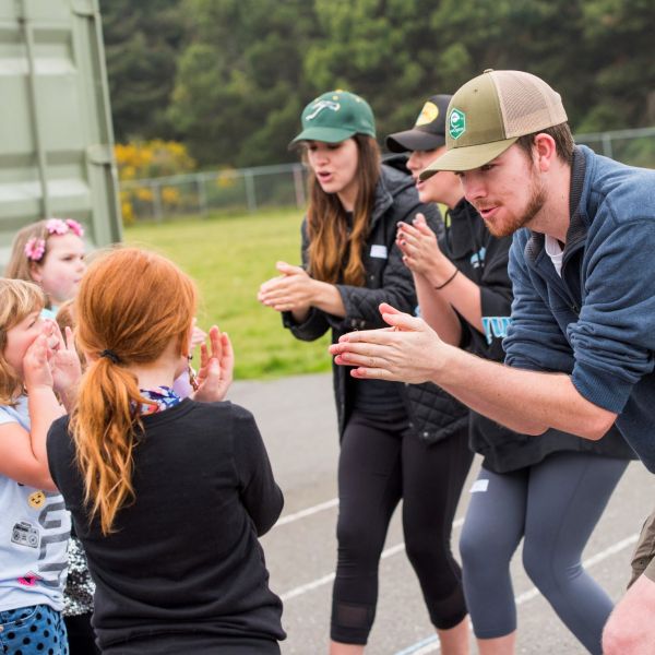 Three college students leading elementary students in an activity