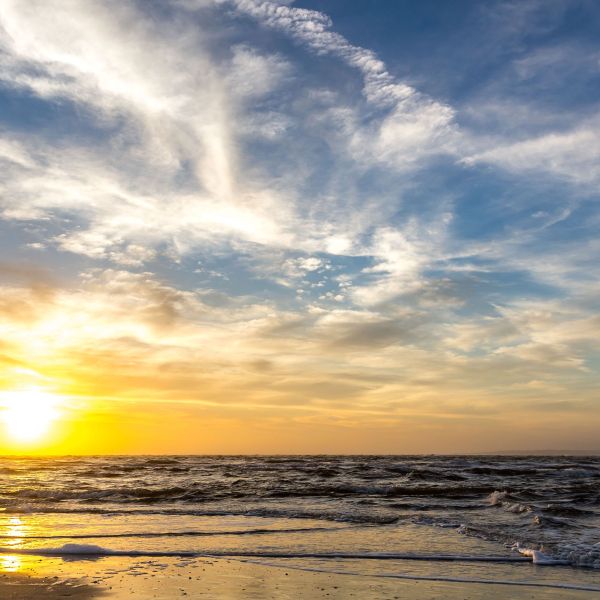 The sun rises at the beach on a cloudy morning over Amelia Island, Florida.