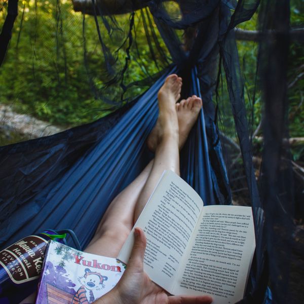Photo of a woman in a hammock with a book in her hand