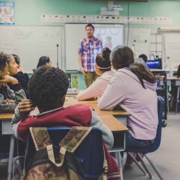 Students sit in a classroom listening to a teacher