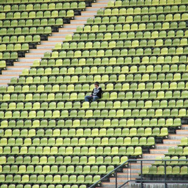 One spectator sitting in an empty stadium