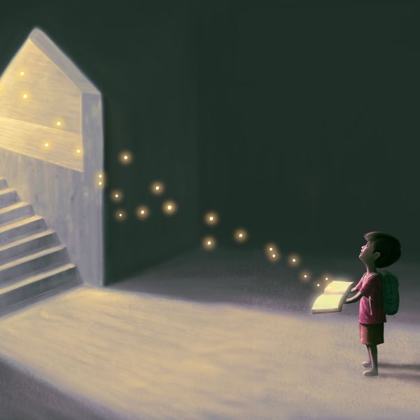 Young child in dark room holding book, flattering lights leading towards a staircase.