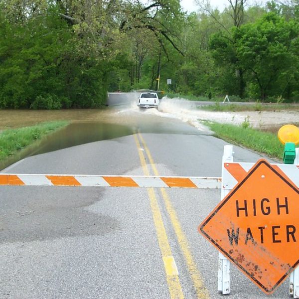High water sign blocks part of a flooded roadway