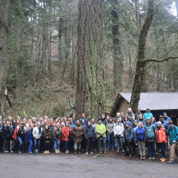 A group of people stand in a forest