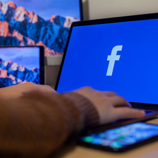 Photo of a laptop screen with the "f" facebook logo shown on screen