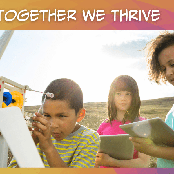 Photo of three students outside studying a model windmill, set against a warm coloful graphic with white text at the top that says, "Together We Thrive"