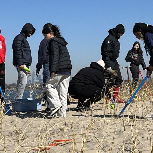 A group of kids on a beach in New York planting dune grass as part of the NWF RiSC program.