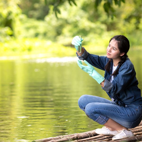 Woman testing water at river edge